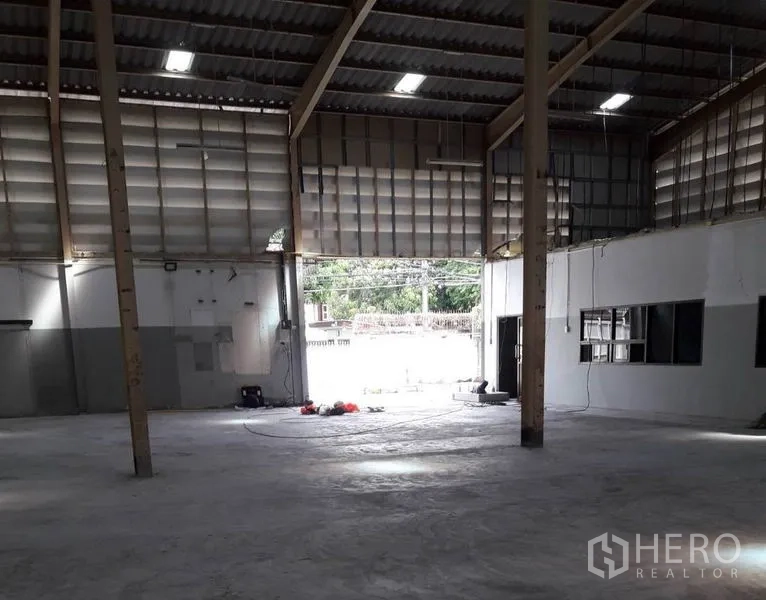 Warehouse for rent in Bang Sue, Bangkok - Warehouse interior with large roller door opening to yard and natural light.