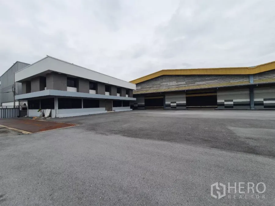 工厂 出租在Mueang Samut Prakan, Samut Prakan - 工厂外立面与两层办公室，前方为宽阔硬化场地