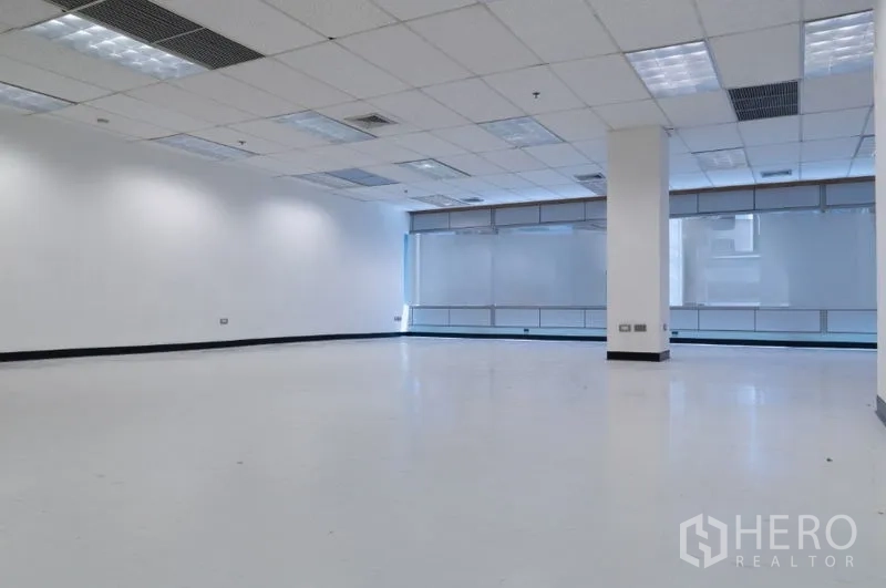สำนักงาน ให้เช่าในRatchathewi, Bangkok - พื้นที่สำนักงานแบบเปิด 145 ตร.ม. พื้นสีขาว เพดานฝ้าทีบาร์ ไฟสว่าง และหน้าต่างบานใหญ่ฝ้าขุ่น