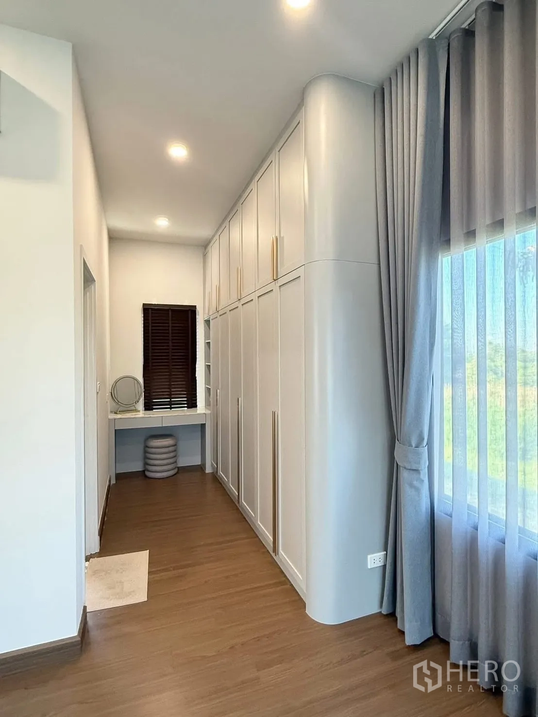 Detached House for rent in Bang Phli, Samut Prakan - Hallway with full-height built-in wardrobes and a small desk by the window.