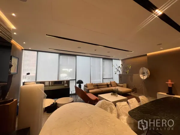 零售空间 出租 - 开放式零售室内，落地窗、筒灯与沙发接待区，旁有石材台面。