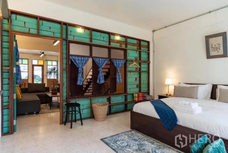 Townhouse for rent in Pathum Wan, Bangkok - Spacious bedroom with teal feature wall and sliding wood partition.