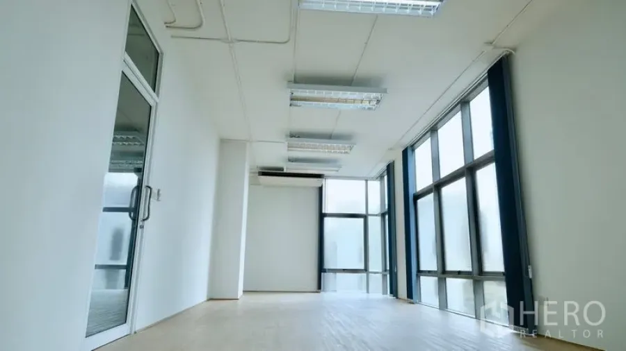办公空间 出租在Bang Rak, Bangkok - 开放式办公室，玻璃入户门、分体空调与落地窗采光。
