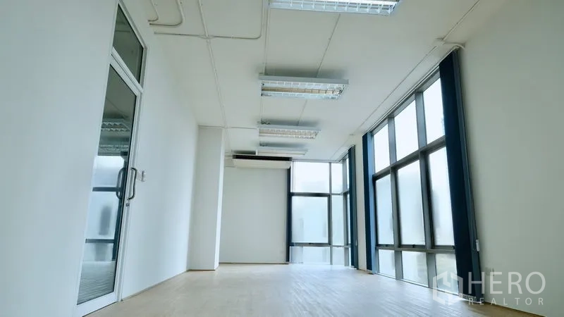 办公空间 出租在Bang Rak, Bangkok - 开放式办公室，玻璃入户门、分体空调与落地窗采光。