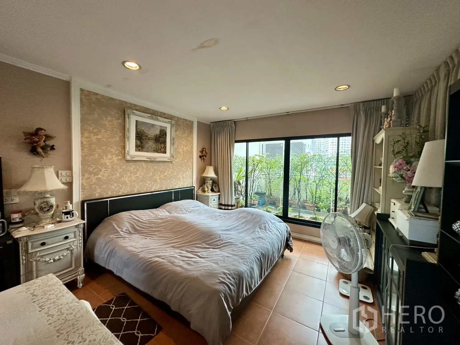 Shophouse for sale in Watthana, Bangkok - Spacious bedroom with large bed and sliding doors to terrace greenery.