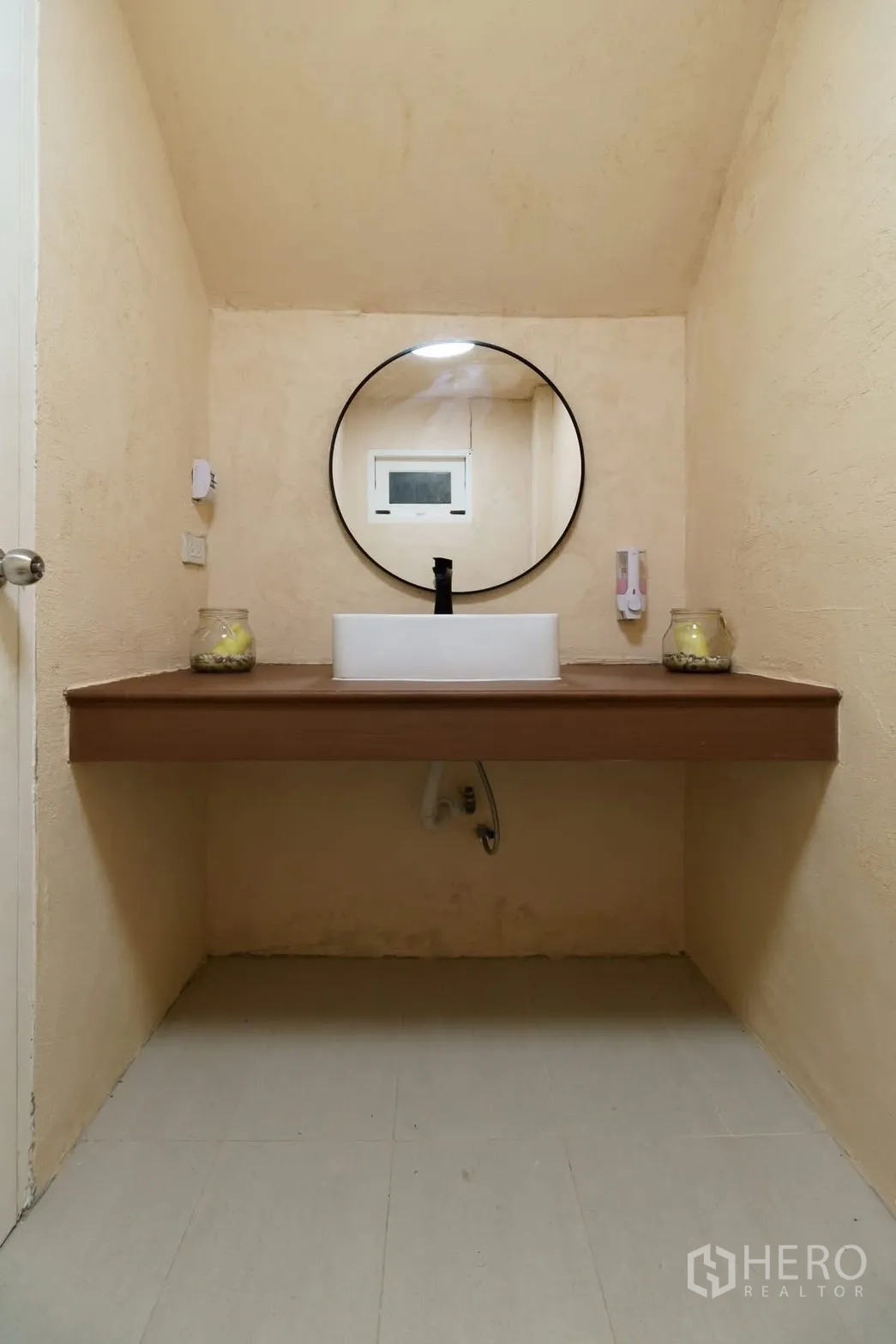 联排别墅 for rent in Watthana, Bangkok - 极简浴室，圆镜与台上盆置于木质台面上。