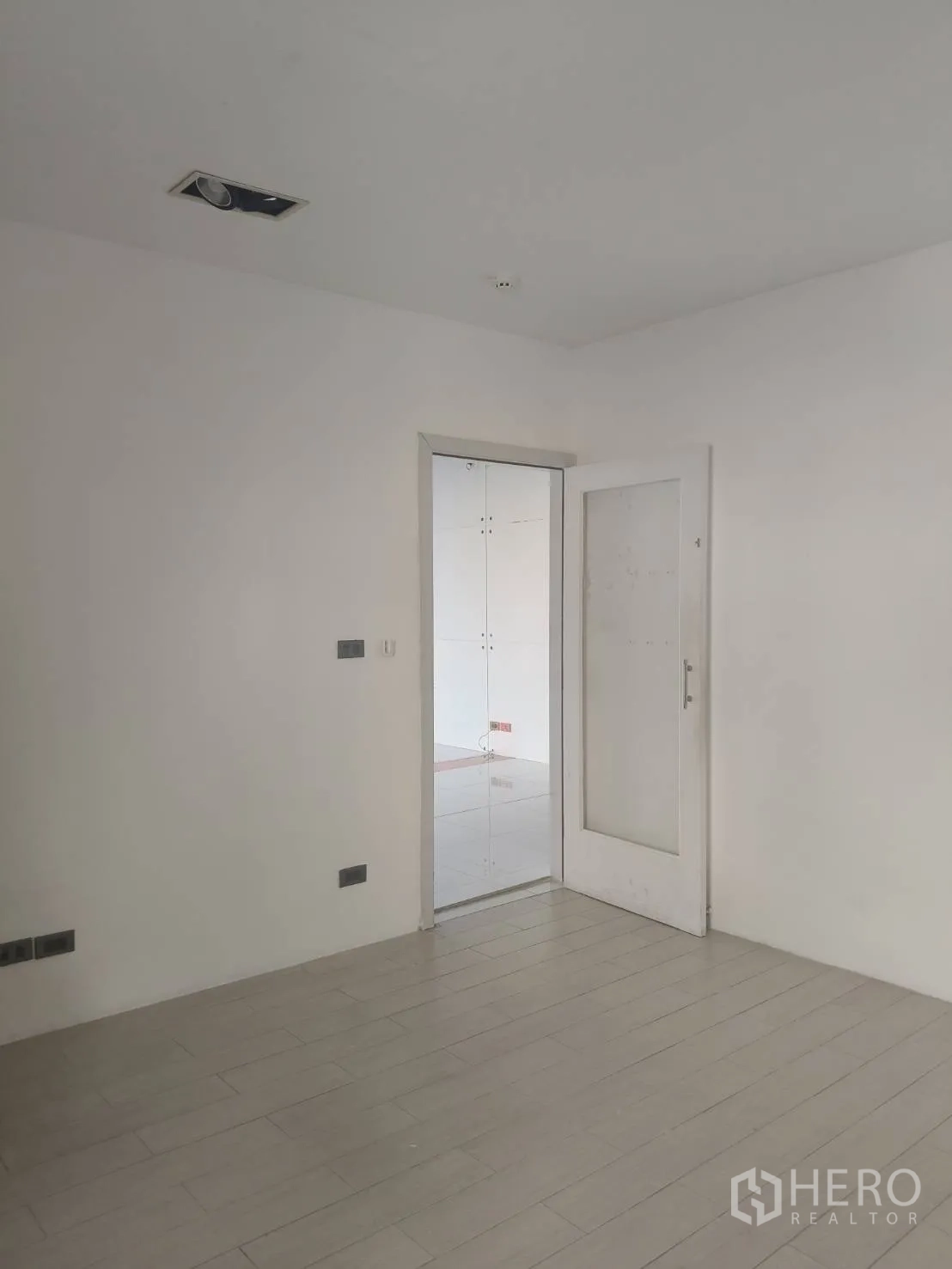 สำนักงาน ให้เช่าในKhlong Toei, Bangkok - ห้องสีขาวมินิมอล พื้นลายไม้ พร้อมประตูกระจกเชื่อมไปยังโซนสำนักงานปูกระเบื้อง