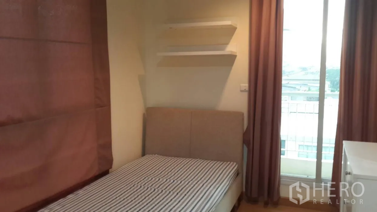 คอนโด ให้เช่าในWatthana, Bangkok - ห้องนอนที่สองมีเตียงเดี่ยว ชั้นลอยติดผนัง ผ้าม่านสูง และทางออกสู่ระเบียงเห็นวิวเมือง