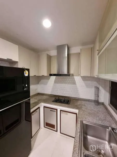 独立式住宅 出租在Bang Kruai, Nonthaburi - L形厨房，燃气灶、抽油烟机与花岗岩台面。