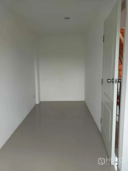 Shophouse for sale in Bueng Kum, Bangkok - Modern three-storey shophouse building with glass fronts and a parking area.