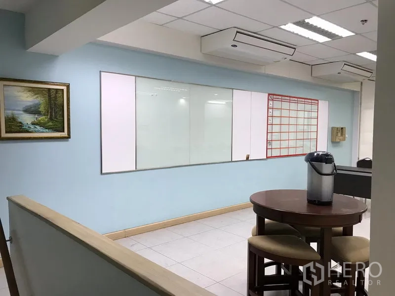 Office Space for rent in Khlong Toei, Bangkok - Breakout area with round table and stools, wall whiteboards and ceiling air-conditioning units.