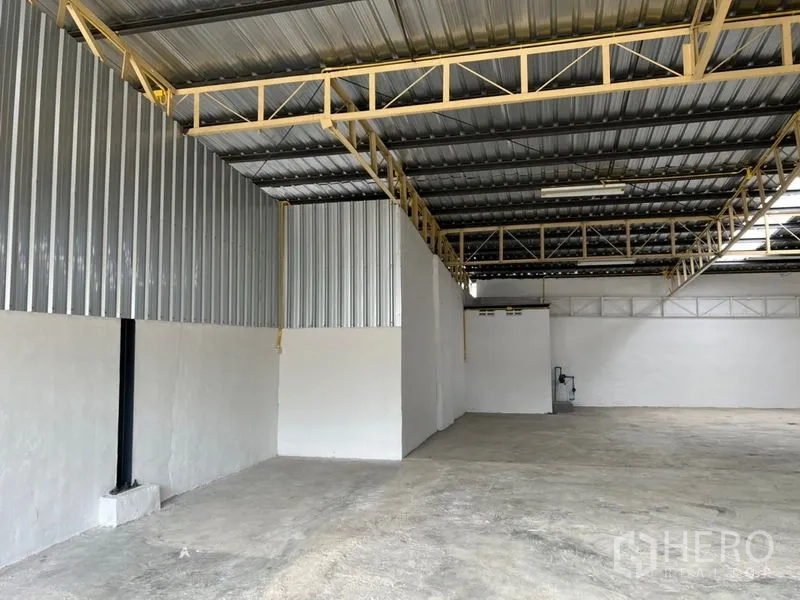 Warehouse for rent in Suan Luang, Bangkok - Open 250 sqm warehouse interior with high steel truss roof and durable concrete floor.