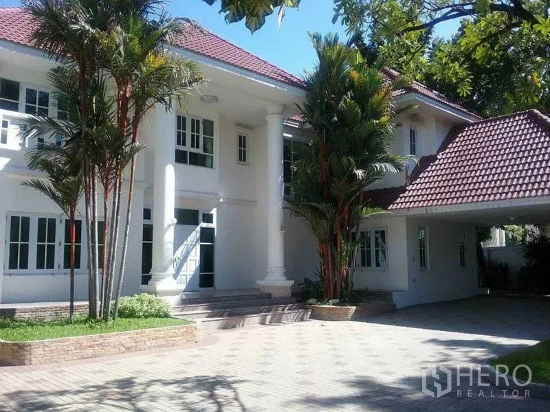 บ้าน ขาย - ด้านหน้าบ้านสไตล์คลาสสิก เสาใหญ่ ที่จอดรถ และต้นปาล์ม