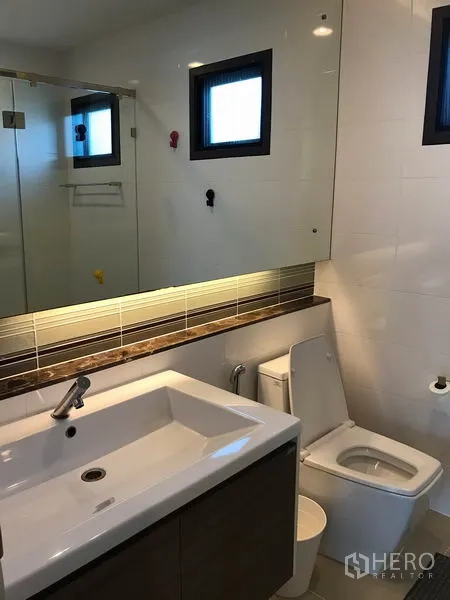 独立式住宅 出租在Bang Kapi, Bangkok - 第二浴室带大镜子、洗手台和马桶。