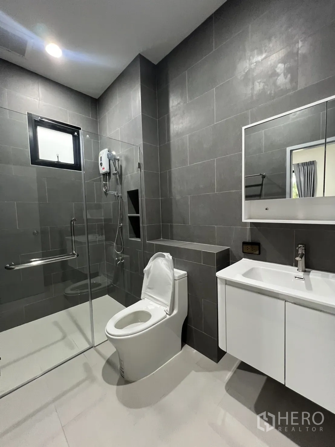 Detached House for rent in Saphan Sung, Bangkok - Modern bathroom with glass-enclosed shower, white vanity, and toilet.