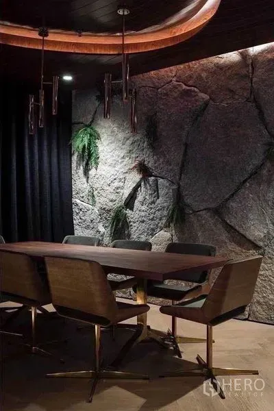 公寓 出租在Watthana, Bangkok - 餐区配木桌、金属脚椅、吊灯与点缀绿植的岩石背景墙