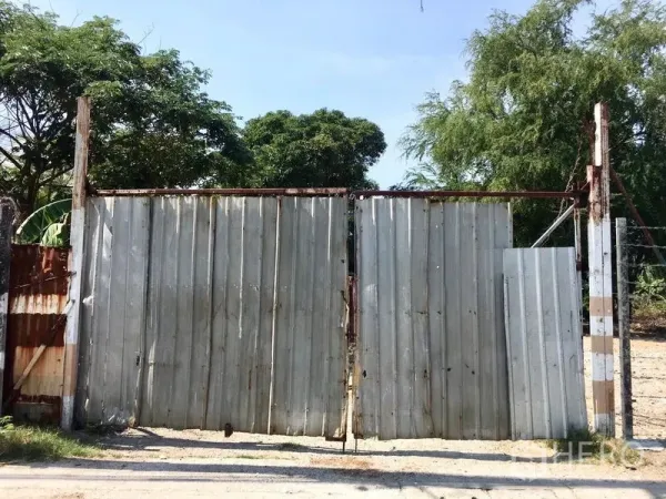 ที่ดิน ให้เช่าในBang Na, Bangkok - ประตูเหล็กลอนสังกะสีของแปลงที่ดินล้อมรั้ว ย่านบางนา กรุงเทพฯ