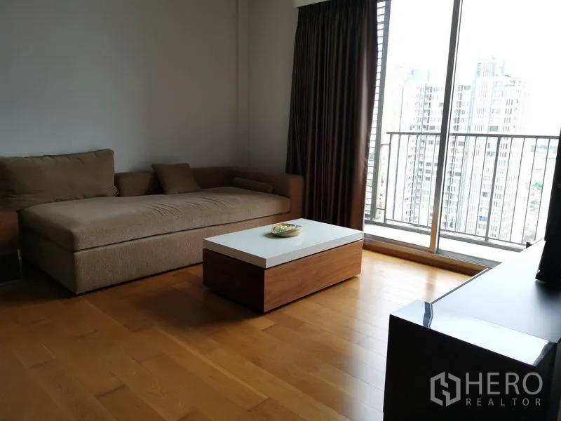 คอนโด ให้เช่าในKhlong San, Bangkok - ห้องนั่งเล่นพร้อมโซฟาตัวแอล โต๊ะกลาง และระเบียงชมวิวเมือง