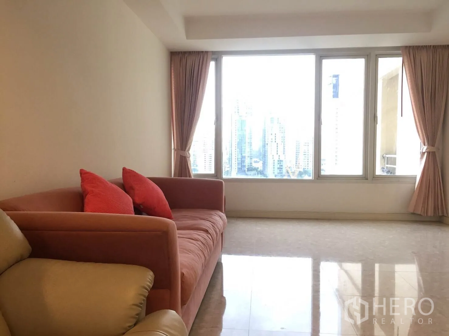 คอนโด ให้เช่าในWatthana, Bangkok - ห้องนั่งเล่นกว้างพร้อมโซฟาสีชมพู หน้าต่างบานใหญ่ พื้นกระเบื้อง และวิวสกายไลน์