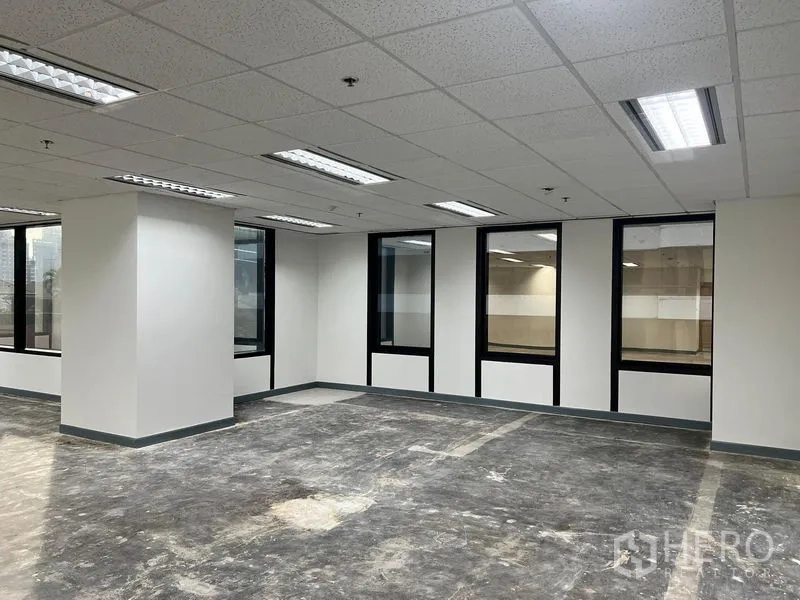 Office Space for rent in Khlong Toei, Bangkok - Bright open-plan office with grid ceiling lights, white walls and large corner windows, ready for fit-out.