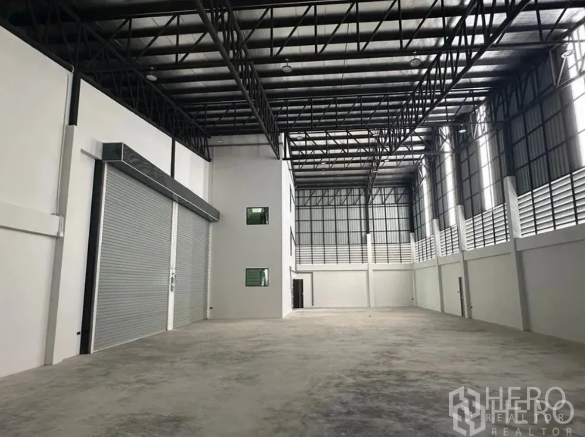 โกดัง for sale in Lam Luk Ka, Pathum Thani - ลานเก็บสินค้าโล่งพร้อมช่องแสงสูง ช่องระบายอากาศบานเกล็ด และประตูม้วนสีเทาคู่
