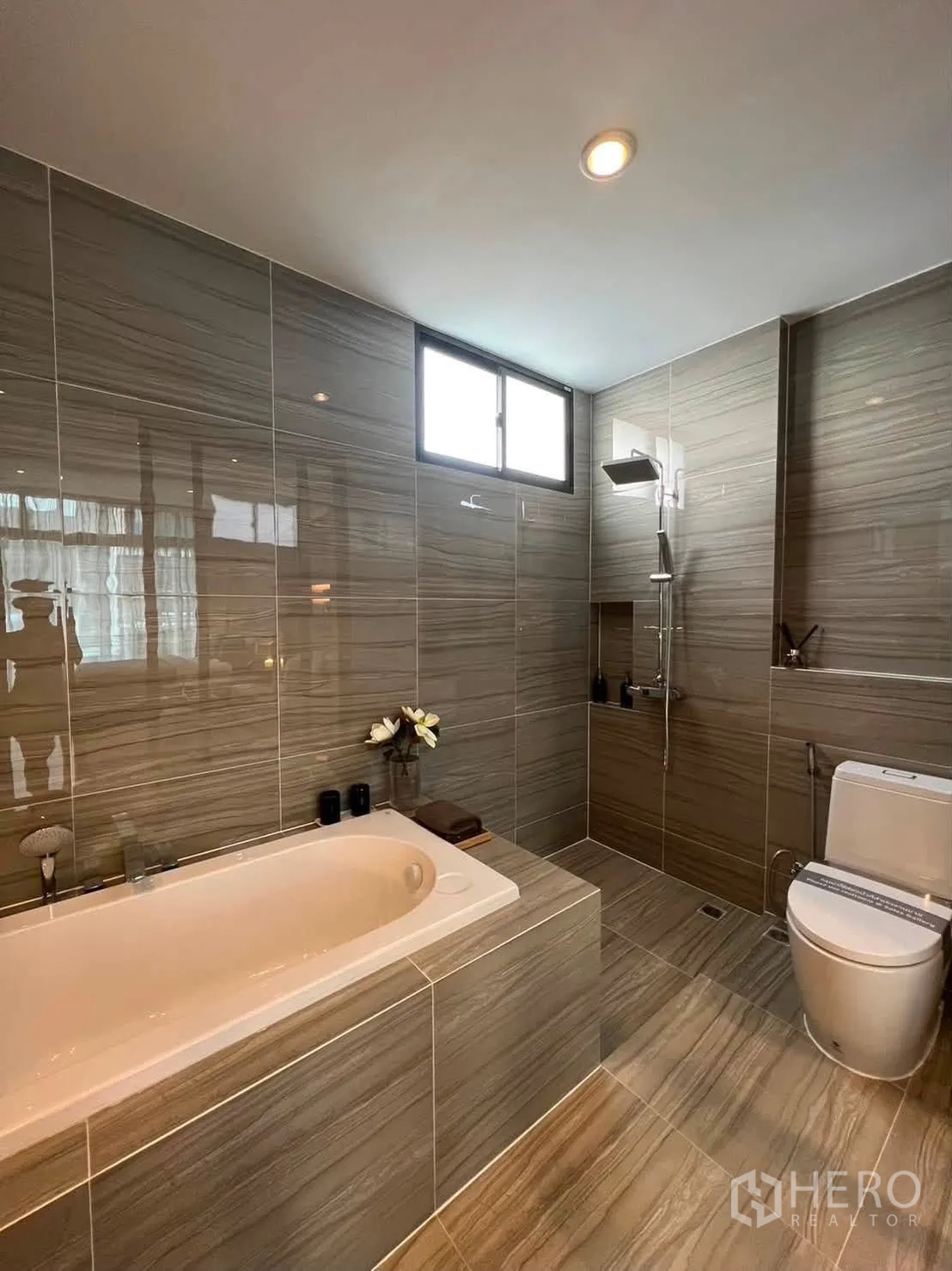 Townhouse for rent in Saphan Sung, Bangkok - Large bathroom with soaking tub, walk-in shower, and toilet under a window.