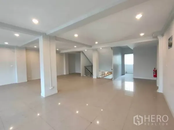 带办公室的家 出租或出售在Bang Na, Bangkok - 宽敞的开放式楼层，亮面地砖、筒灯照明与中央楼梯。