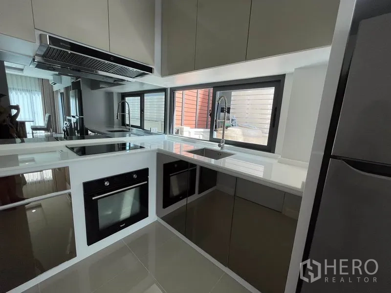 บ้าน ให้เช่าในPrawet, Bangkok - ครัวรูปตัวยูบิวท์อิน พร้อมเตาอบ เตาไฟฟ้า และหน้าต่างเหนืออ่างล้างจาน