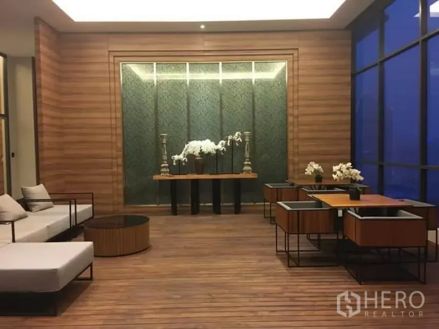 公寓 出租在Watthana, Bangkok - 瓦他那区豪华公寓的木质休闲区，摆放兰花与座椅。