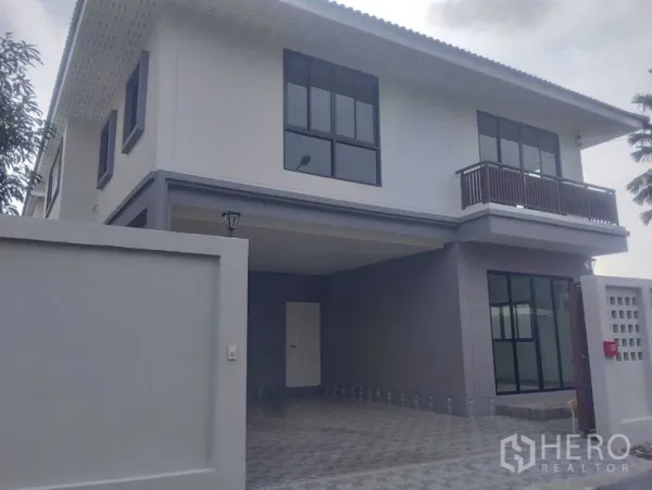 独立式住宅 出售在Phra Khanong, Bangkok - 独栋房屋正立面，围墙、大窗与有顶车库一览。