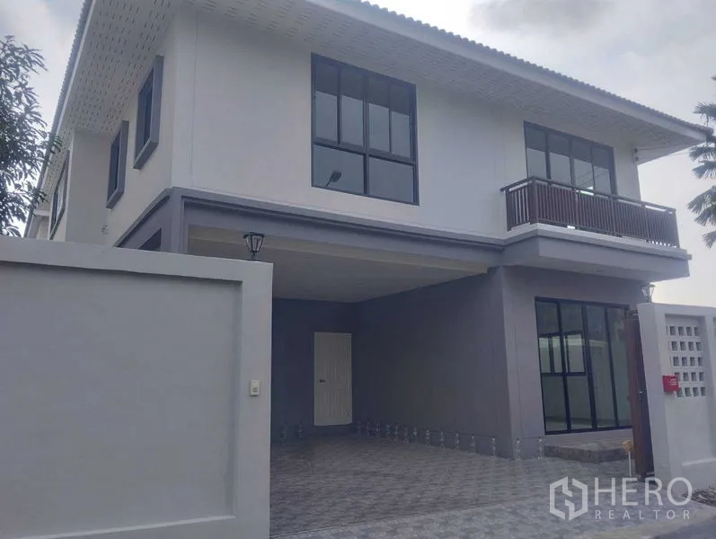 บ้าน ขายในPhra Khanong, Bangkok - ด้านหน้าบ้านเดี่ยว แสดงกำแพงรั้ว หน้าต่างสูง และโรงจอดรถ