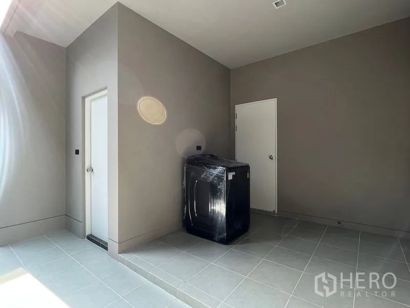 บ้าน ให้เช่าในBueng Kum, Bangkok -  พื้นที่ซักล้างในร่ม ปูกระเบื้อง มีประตูเก็บของและเครื่องซักผ้าใหม่