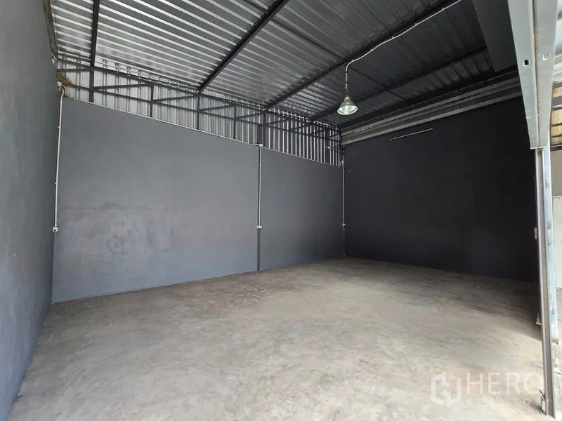 Warehouse for rent in Don Mueang, Bangkok - Empty storage bay with high metal roof, concrete floor, and industrial lighting.