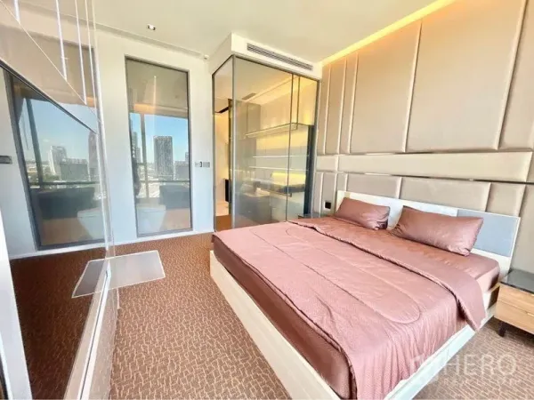 Condominium for rent in Watthana, Bangkok - Master bedroom with upholstered headboard, glass partitions and skyline views.
