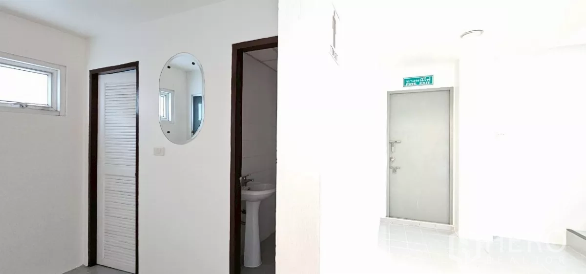 Office Space for rent in Bueng Kum, Bangkok - Hallway with restroom entrance, wall mirror and fire exit signage.