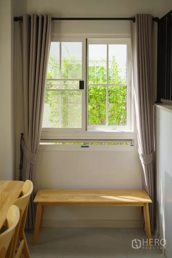 Detached House for rent in Bang Phli, Samut Prakan - Corner window with grey curtains and a wooden bench.