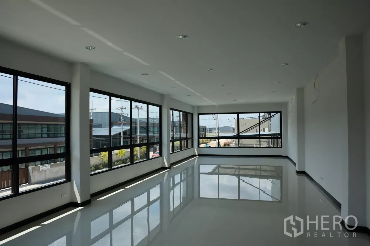 Factory for rent or sale in Bang Len, Nakhon Pathom - Bright second-floor office space with corner windows and glossy tile flooring overlooking the compound.