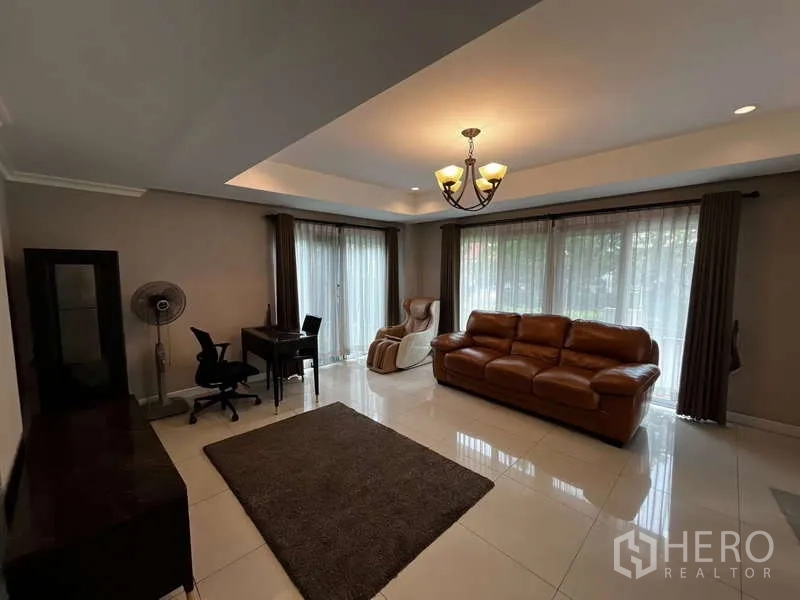 บ้าน ให้เช่าในPrawet, Bangkok - มุมมองอีกด้านของห้องนั่งเล่นสว่าง พร้อมโต๊ะทำงานและหน้าต่างบานใหญ่.