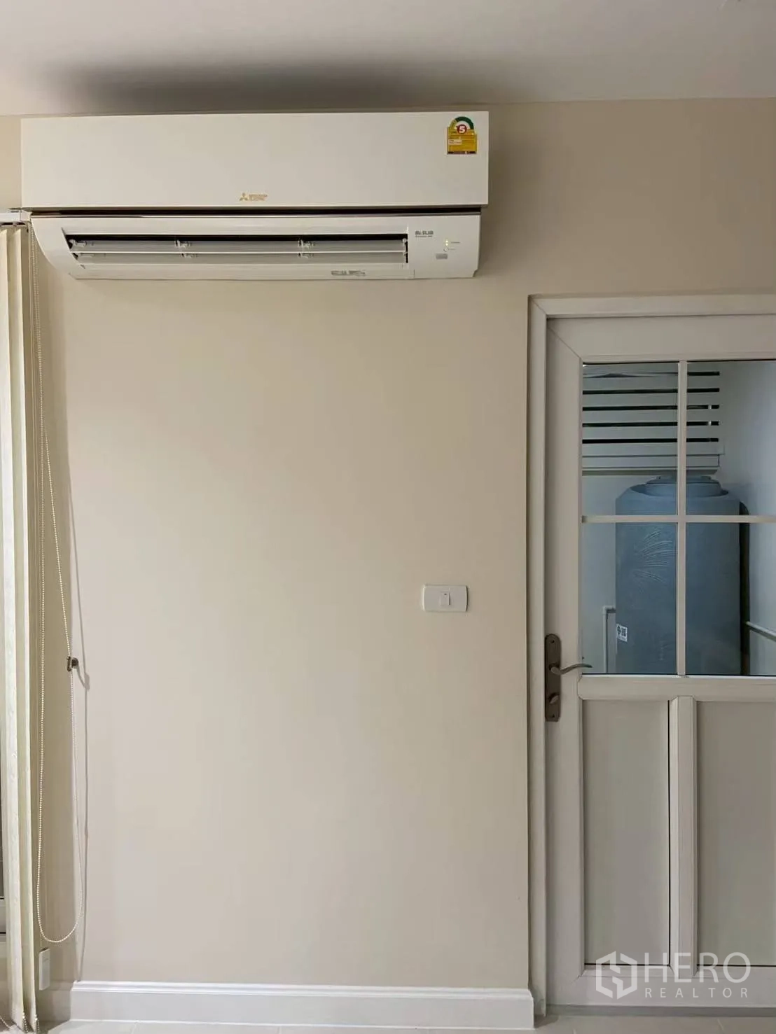 Townhouse for rent in Bang Kapi, Bangkok - Wall-mounted air conditioner beside glass door.