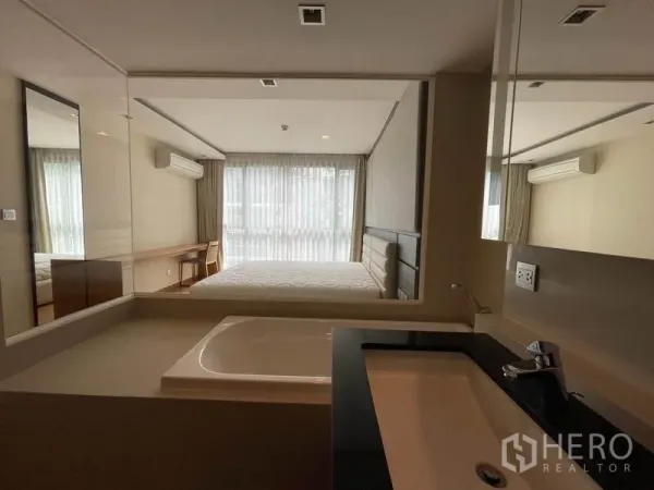 คอนโด ขายในWatthana, Bangkok - อ่างล้างหน้าห้องน้ำ มองผ่านผนังกระจกเข้าสู่ห้องนอนสว่าง