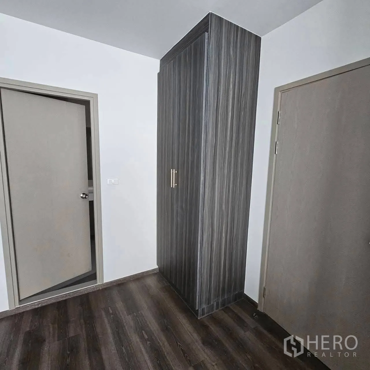 公寓 for rent in Huai Khwang, Bangkok - 过道角落设木纹高柜，位于两扇室内门之间。