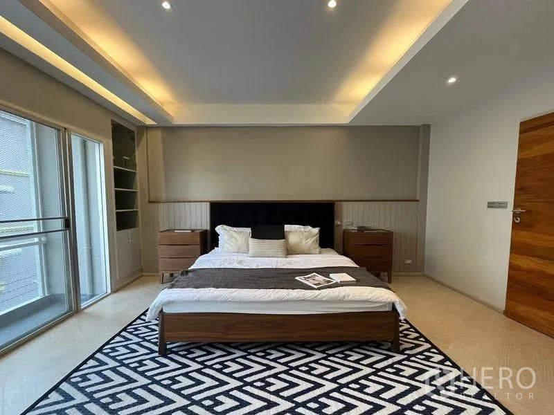 联排别墅 for rent in Phra Khanong, Bangkok - 主卧配床与床头柜，嵌入式照明并可通往阳台。