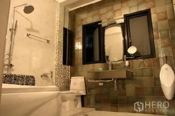 Detached House for rent in Wang Thonglang, Bangkok - Modern bathroom with bathtub, shower, toilet, urinal and a tiled feature wall.