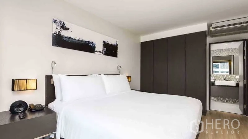 Apartment for rent in Watthana, Bangkok - Bedroom with built-in wardrobe and access to the ensuite bathroom.