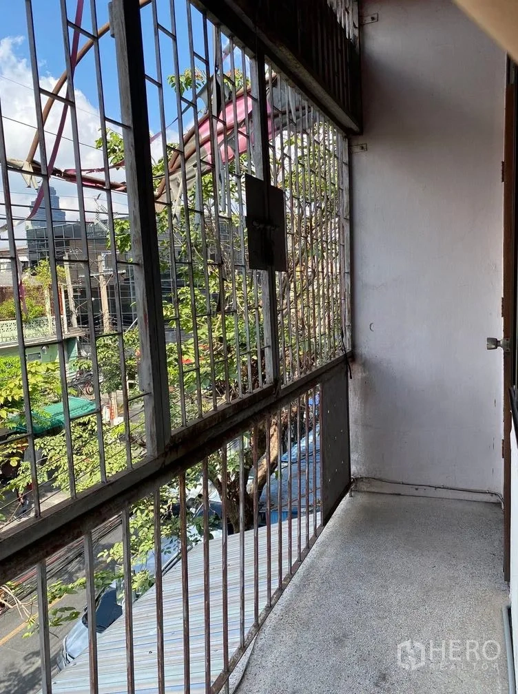 พื้นที่ขายปลีก ให้เช่าในSathon, Bangkok - ระเบียงแคบติดเหล็กดัด มองเห็นถนนย่านชุมชนมีต้นไม้
