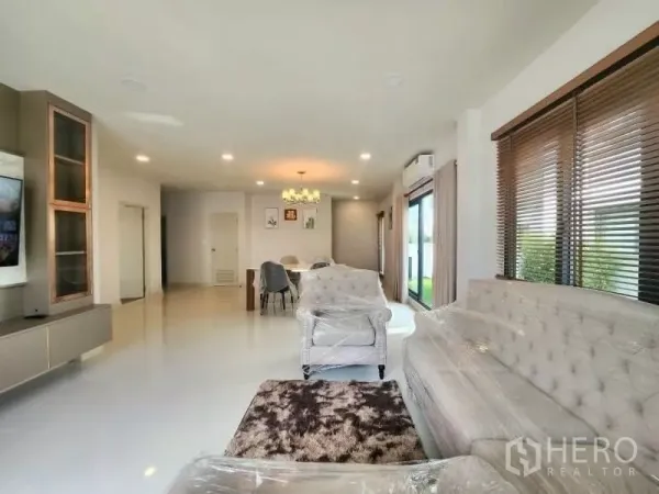 Detached House for rent in Bang Phli, Samut Prakan - Spacious living-dining area with TV wall, sliding glass doors and recessed lighting.