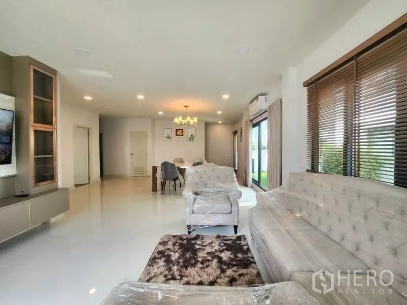 Detached House for rent in Bang Phli, Samut Prakan - Spacious living-dining area with TV wall, sliding glass doors and recessed lighting.
