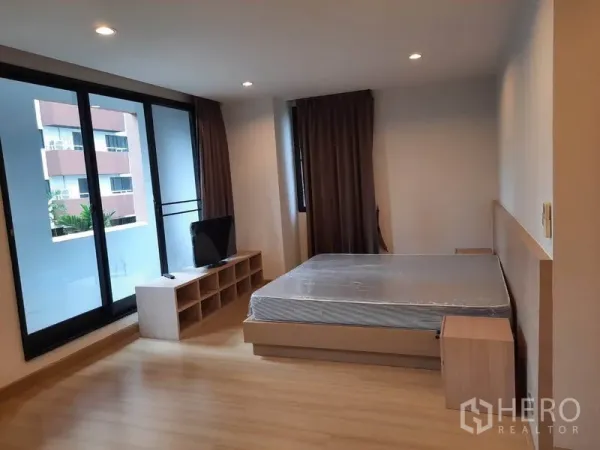 คอนโด ให้เช่าในWatthana, Bangkok - ห้องนอนมาสเตอร์กว้าง มีประตูกระจกบานเลื่อนออกระเบียง เตียง และชั้นวางทีวี พร้อมไฟดาวน์ไลท์