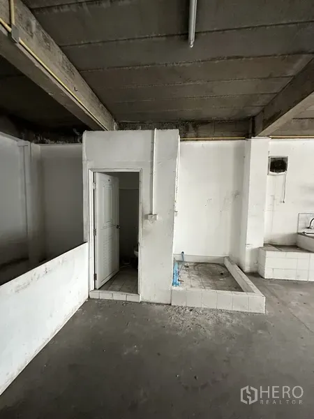 零售空间 出租在Khlong Toei, Bangkok - 未完成房间的设备角，带卫生间门与管线底座。