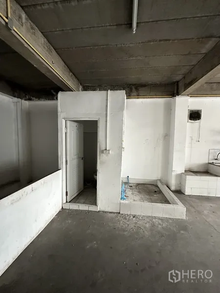 零售空间 出租在Khlong Toei, Bangkok - 未完成房间的设备角，带卫生间门与管线底座。